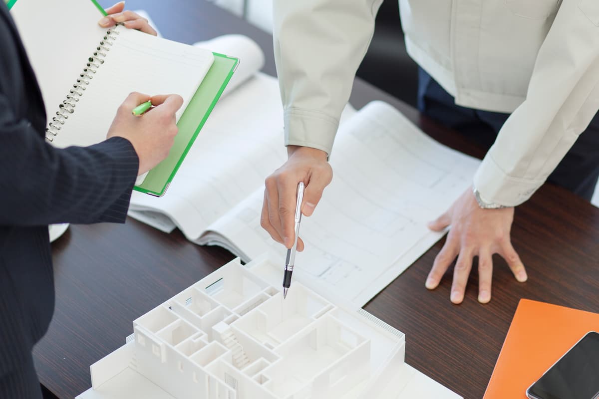 書かれた建築図面と模型を比較する様子